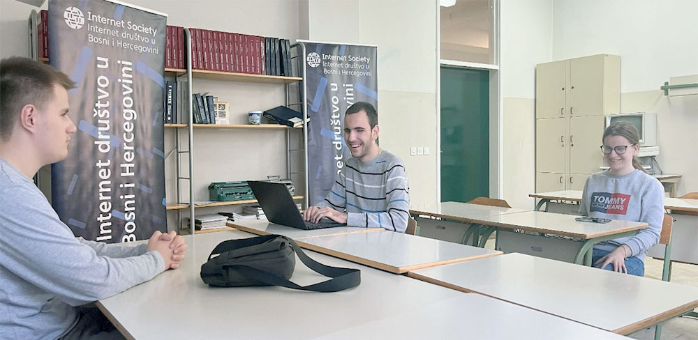 Three people sit at tables at a Bosnia and Herzegovina Chapter safety training