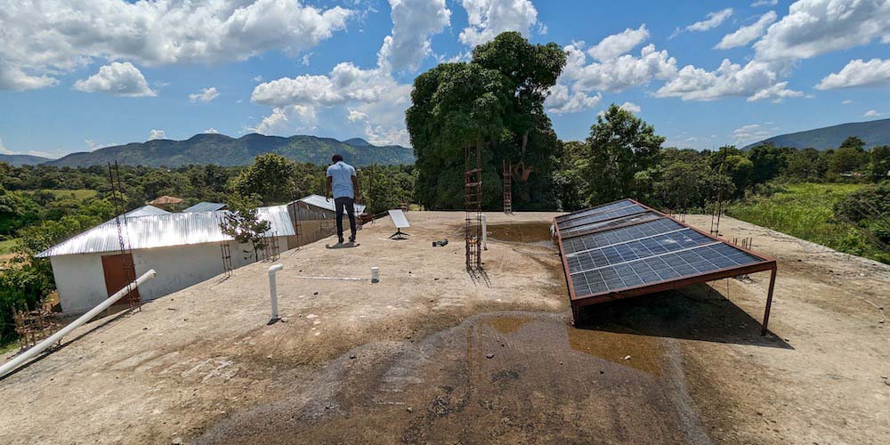A man stands on a roof with Internet infrastructure