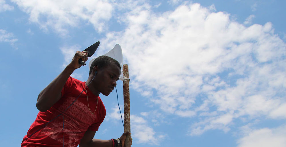 A young man stands and holds connectivity materials at an community networks training