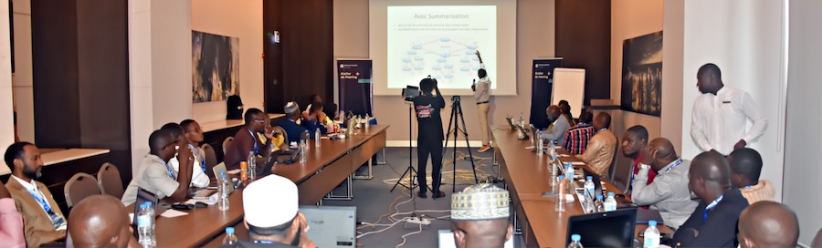 a man presents in a conference room pointing on a screen