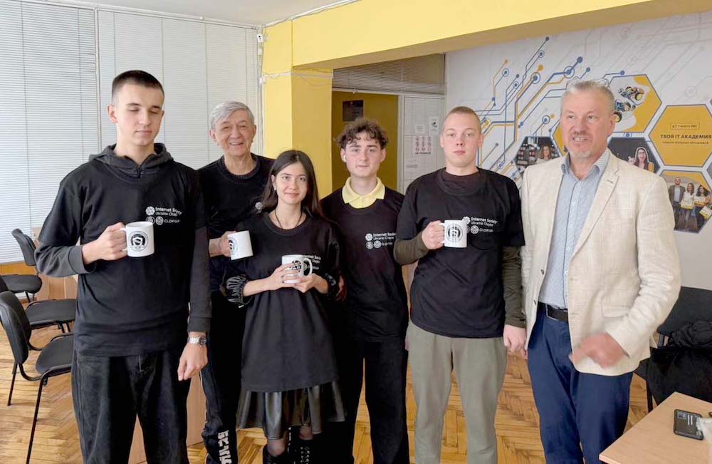 Six people stand together, most of them wearing black Internet Society Ukraine Chapter t-shirts
